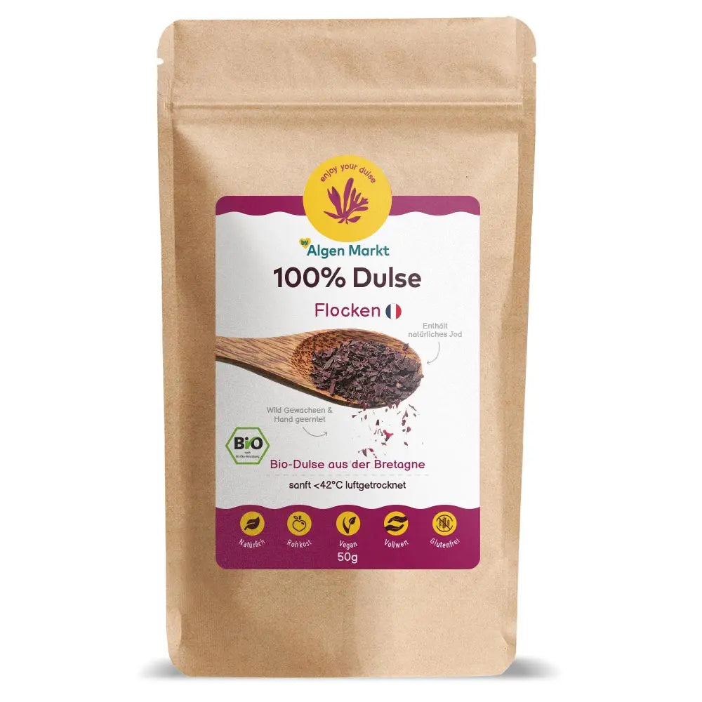 Bio Dulse Flocken 50g von Algenmarkt – rote Algenflocken auf Holzlöffel vor Kraftpapierbeutel