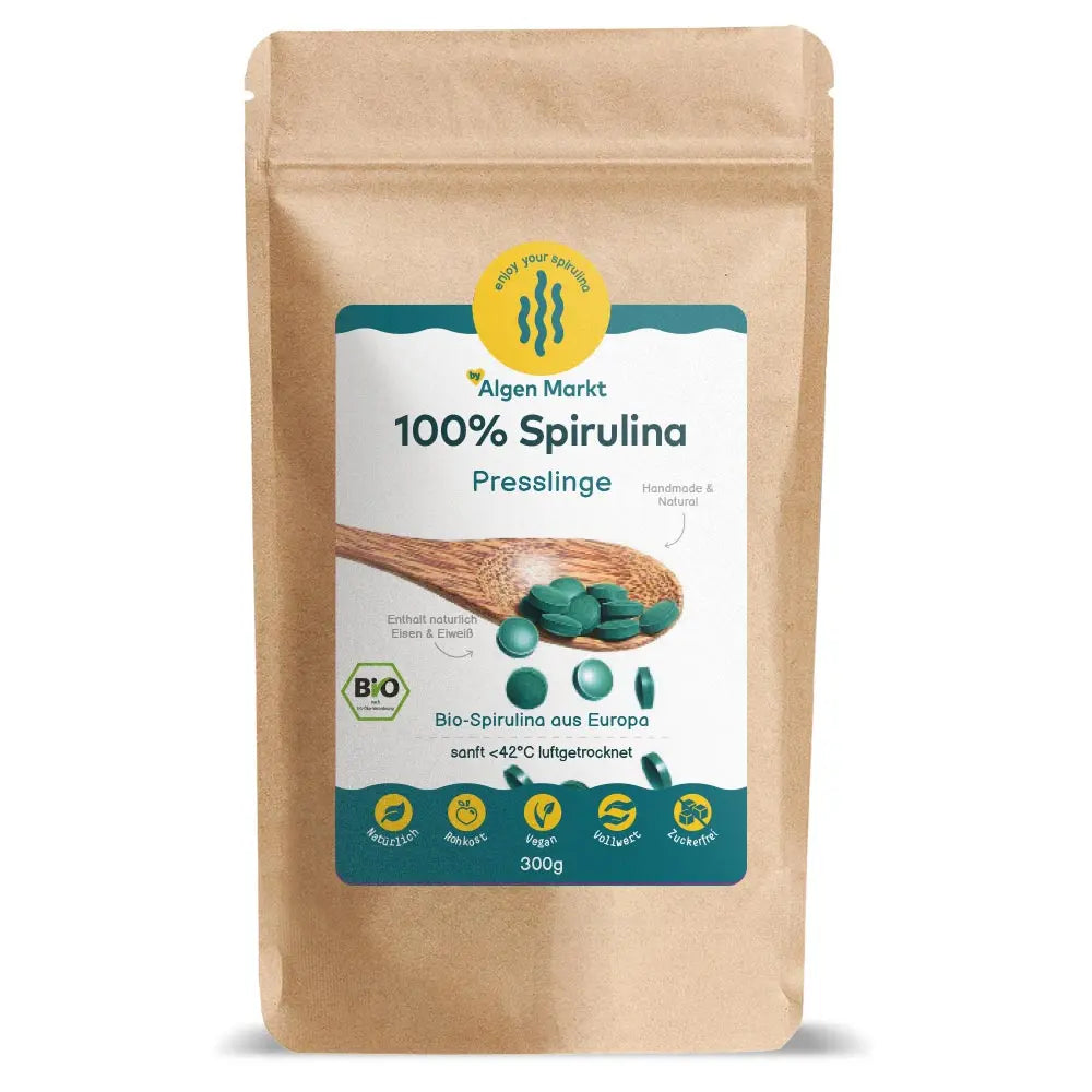 Bio Spirulina Presslinge 300g von Algenmarkt – grüne Tabletten auf Holzlöffel vor Kraftpapierbeutel