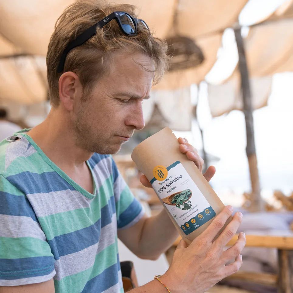 Mann riecht an Bio Spirulina Flocken 100g von Algenmarkt